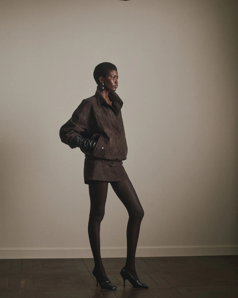 Brown jacket and shorts with black tights and gloves