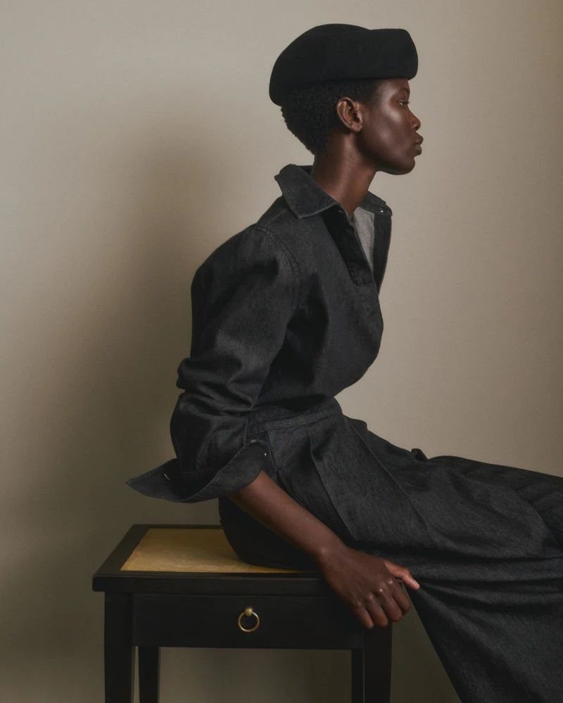 Seated profile in charcoal separates and a black beret