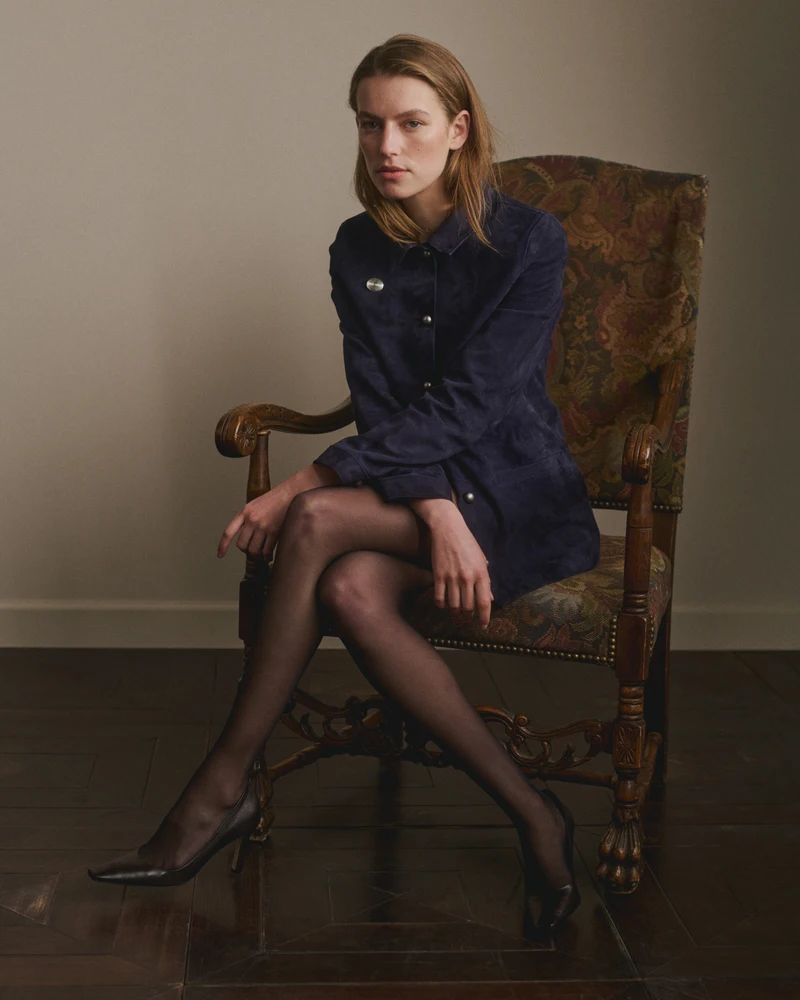 Seated model in a short dark dress