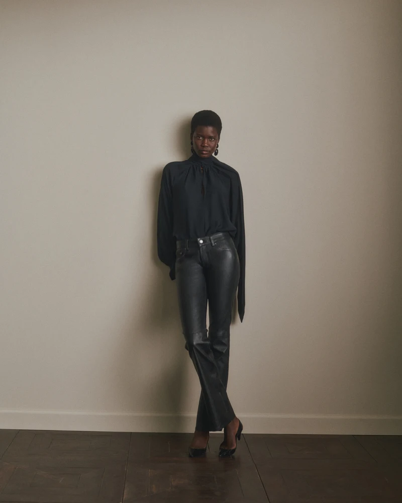 Full-length view of the black blouse and dark trousers
