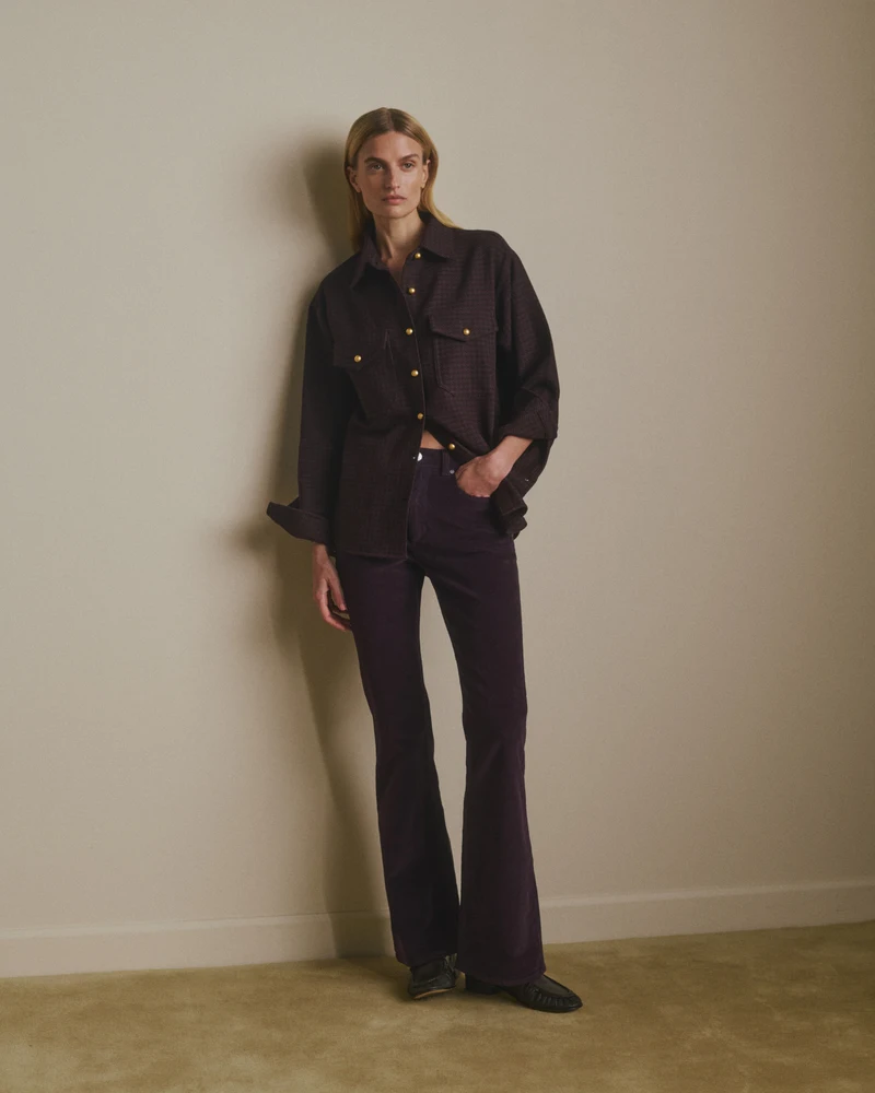 Dark shirt and wide trousers in a standing portrait