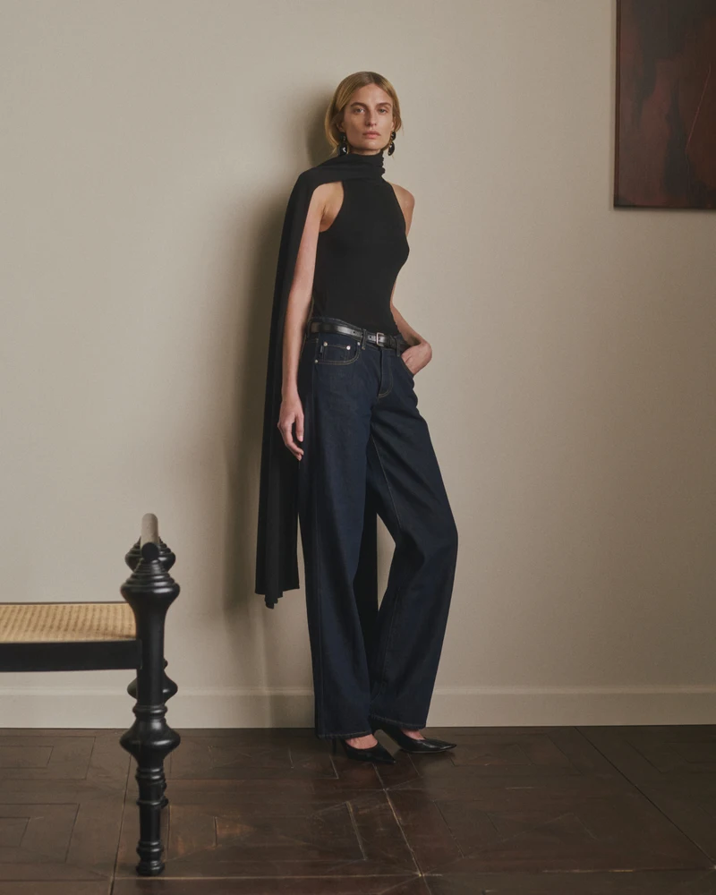 Black sleeveless top with blue wide-leg jeans