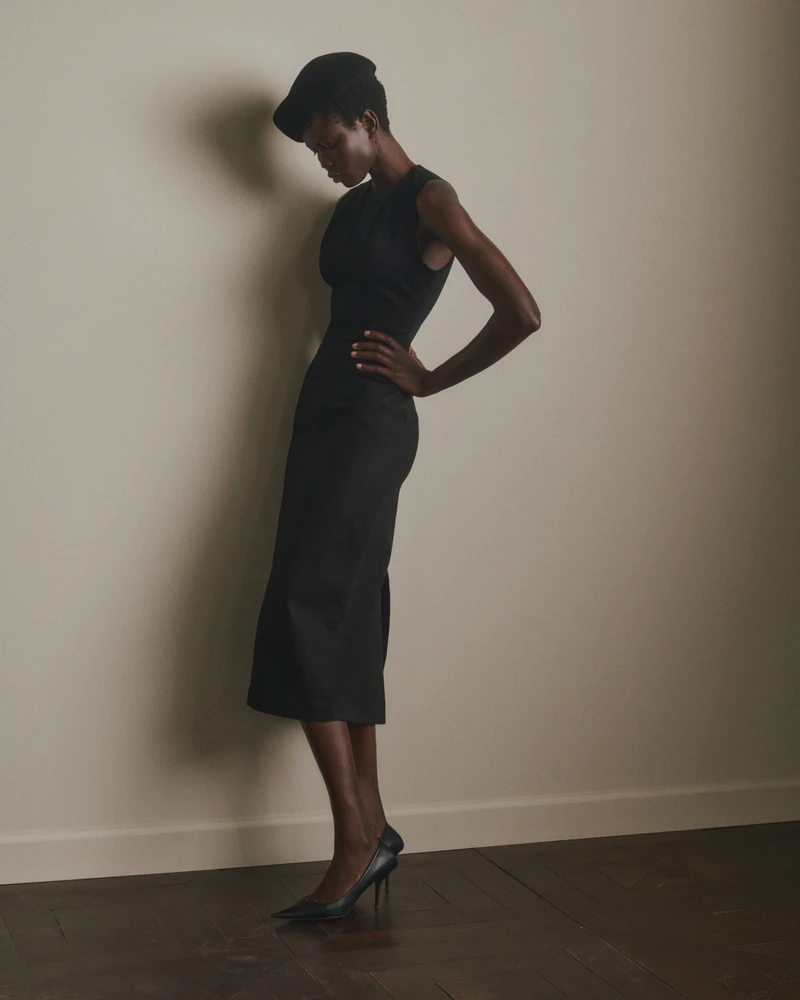 Black sleeveless dress in a full-length portrait