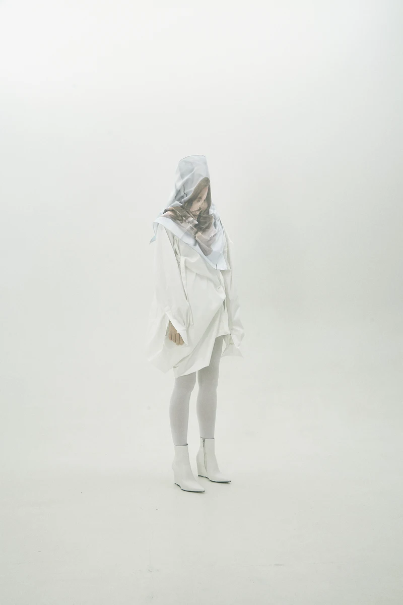 Three-quarter white shirt look with a portrait scarf over the head