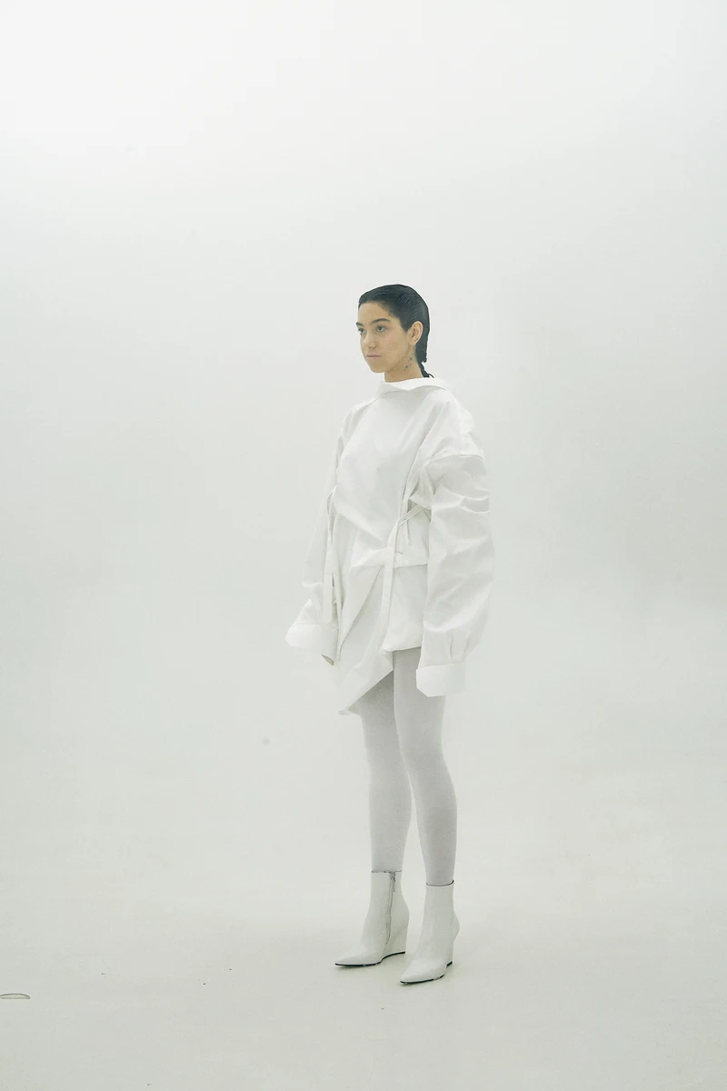 Three-quarter white shirt look with sculpted sleeve volume