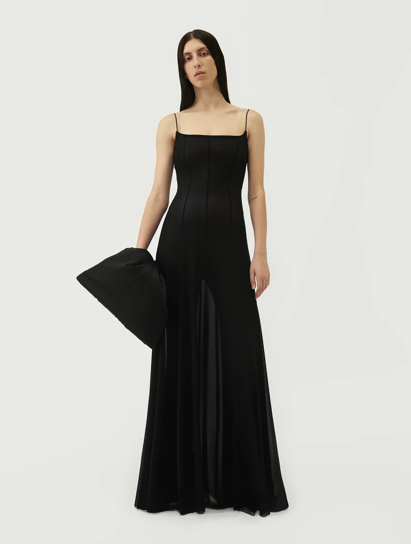 Black wrist bag held with a long black dress