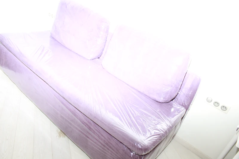 Sofa covered in pale translucent plastic